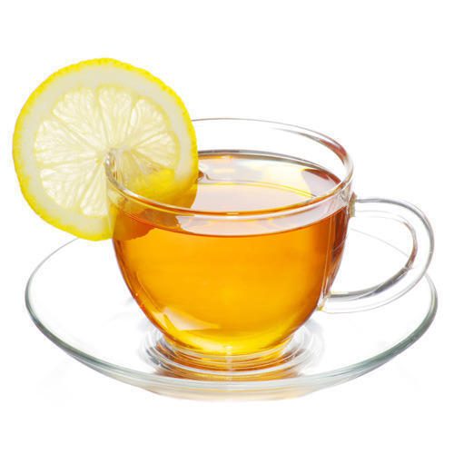 A hand adding lemon and honey into Moringa tea with cinnamon stick beside the cup