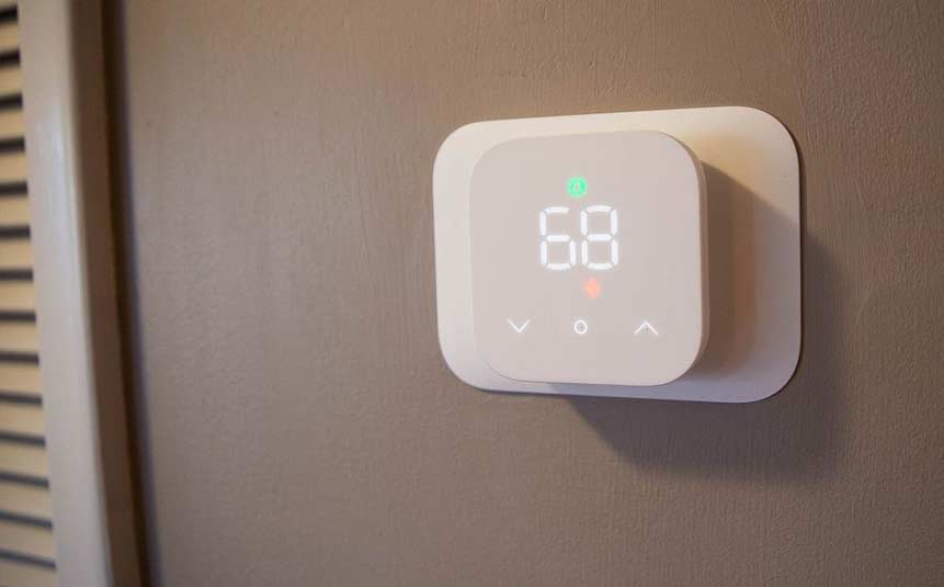 Amazon smart thermostat mounted on wall with simple digital display