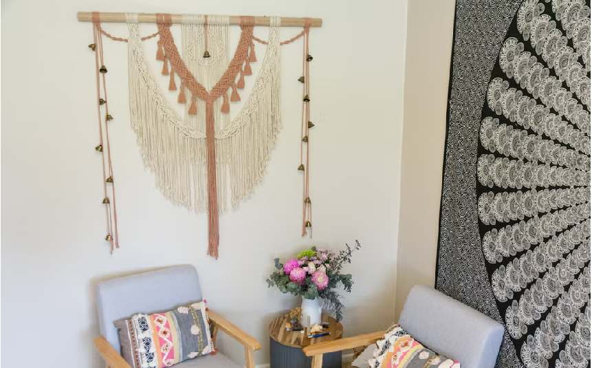 Boho fabric wall hanging with patterns on a living room wall