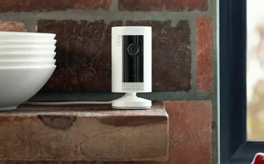 Compact smart security camera placed on a shelf indoors