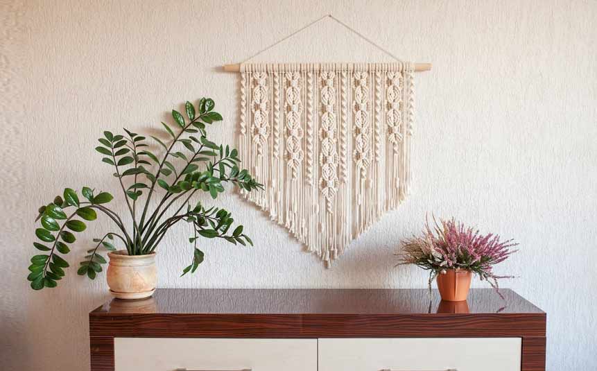 Handmade DIY macramé wall hanging on a white wall