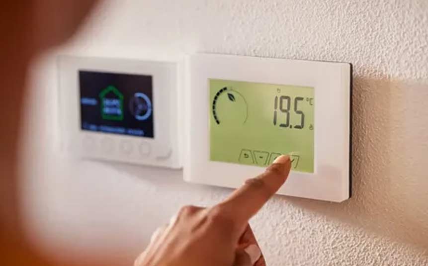 Smart thermostat showing digital display on a living room wall