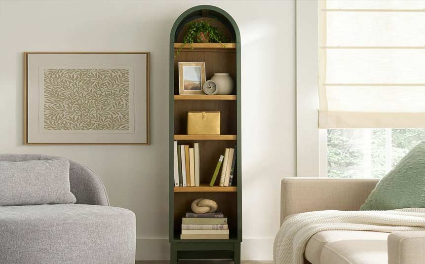Tall narrow bookshelf against a wall in a small bedroom