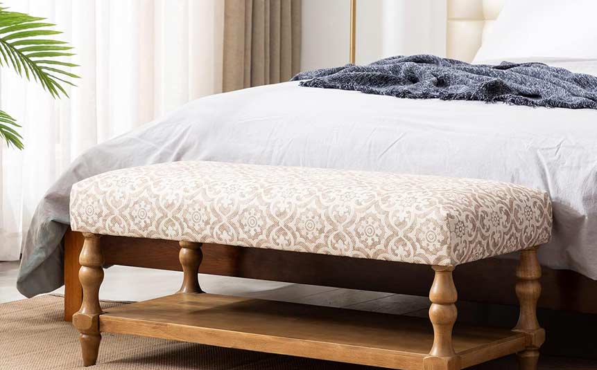 Upholstered storage bench at the foot of a bed